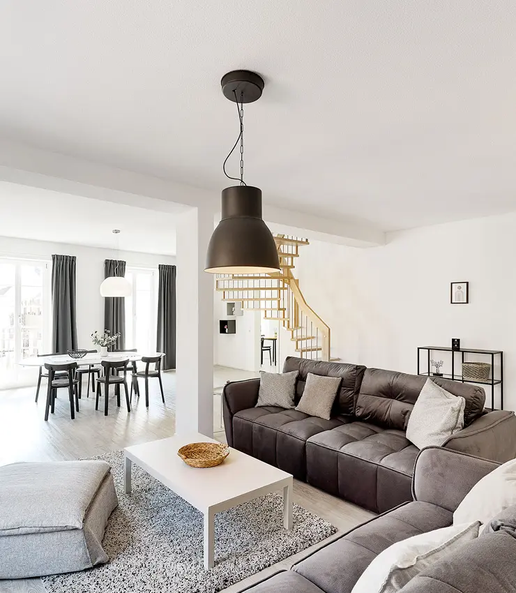 Deko-Schriftzug 'Relax' auf einem Holztisch mit Blumenvase im Appartement